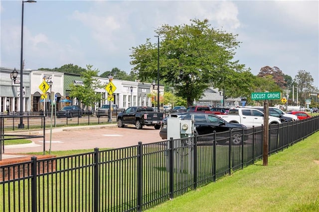 view of parking / parking lot featuring a lawn