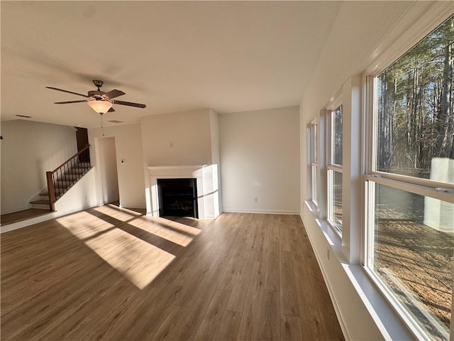 unfurnished living room with ceiling fan and dark hardwood / wood-style flooring