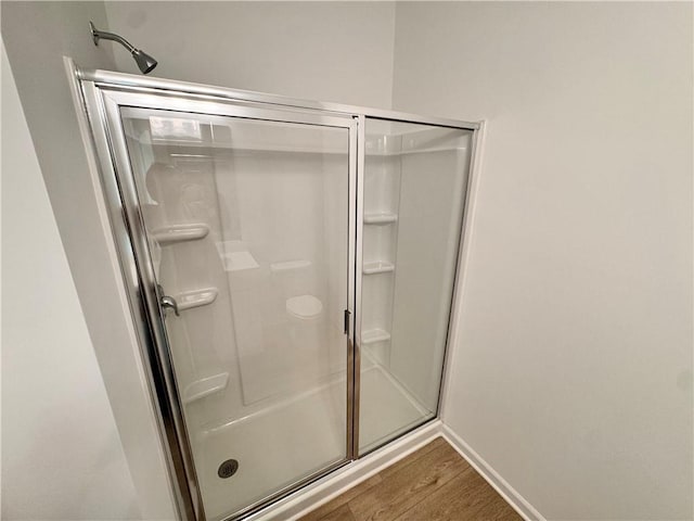 bathroom with hardwood / wood-style floors and an enclosed shower