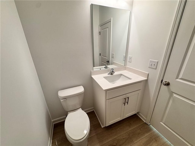 bathroom with vanity, hardwood / wood-style flooring, and toilet