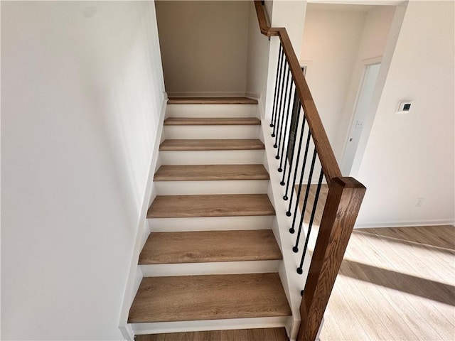 stairs featuring hardwood / wood-style floors