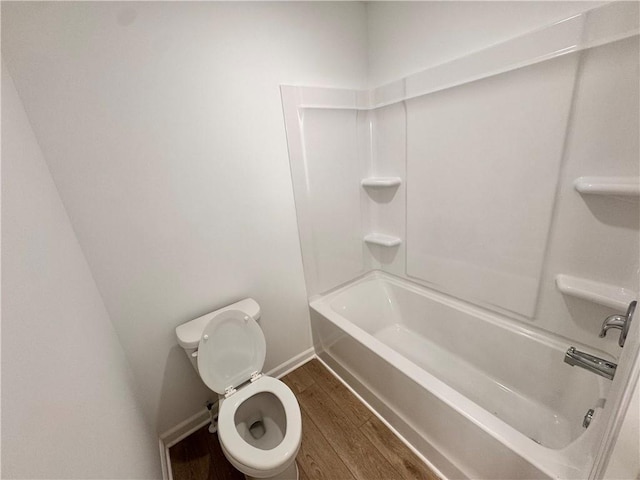 bathroom featuring toilet, wood-type flooring, and bathing tub / shower combination