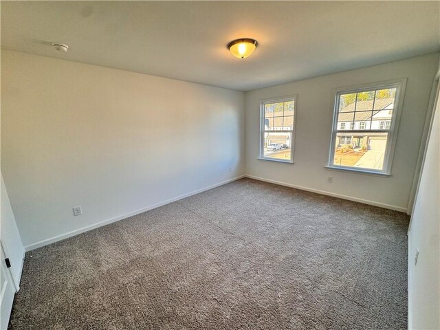 unfurnished room with dark carpet