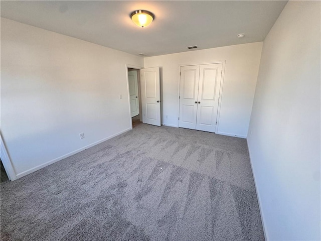 unfurnished bedroom featuring carpet flooring and a closet