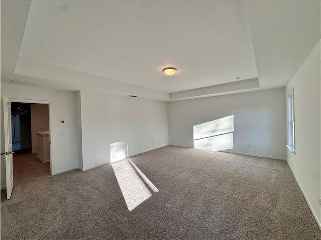 carpeted empty room with a tray ceiling