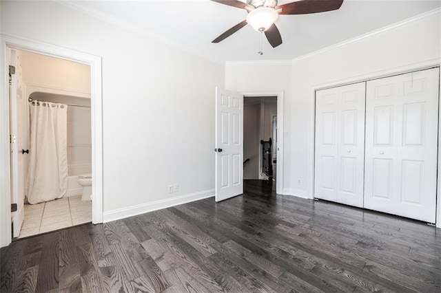 unfurnished bedroom with dark wood-type flooring, ceiling fan, ensuite bathroom, ornamental molding, and a closet