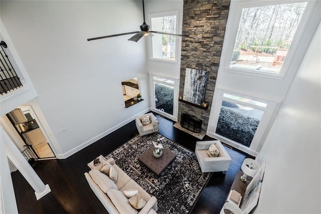 living room with a fireplace, dark hardwood / wood-style floors, and a high ceiling