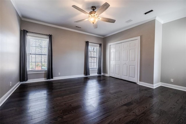 unfurnished bedroom with dark hardwood / wood-style floors, ornamental molding, a closet, and ceiling fan