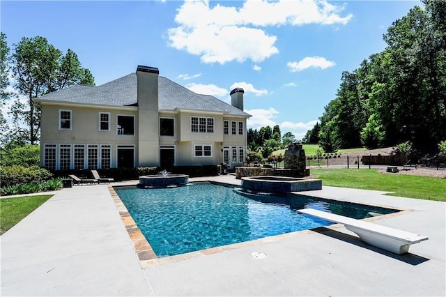 view of swimming pool featuring an in ground hot tub, a yard, a diving board, and a patio area