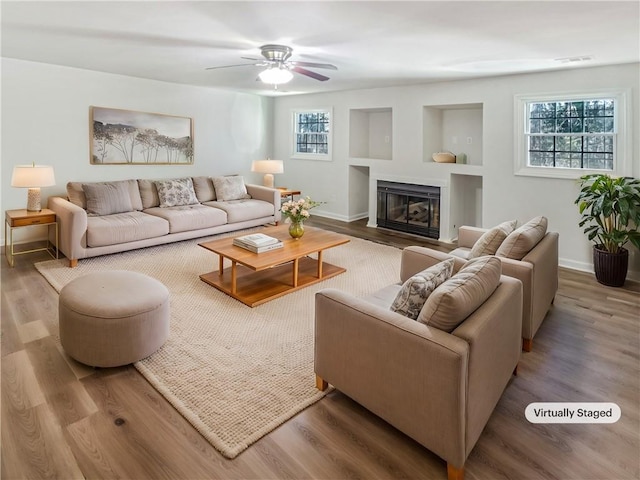 living room featuring plenty of natural light, ceiling fan, and wood-type flooring