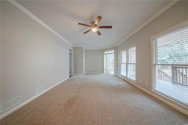 empty room featuring baseboards, visible vents, light colored carpet, and ornamental molding