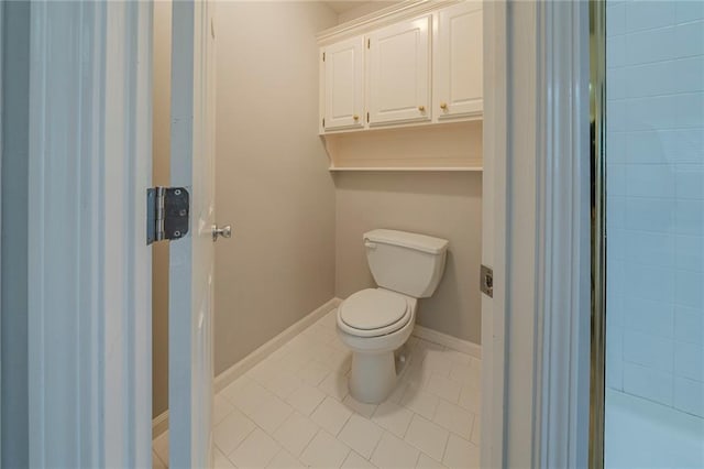 bathroom featuring tile patterned flooring, toilet, and baseboards