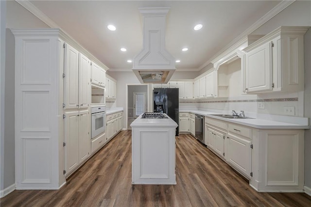 kitchen featuring white cabinetry, stainless steel appliances, light countertops, and a center island