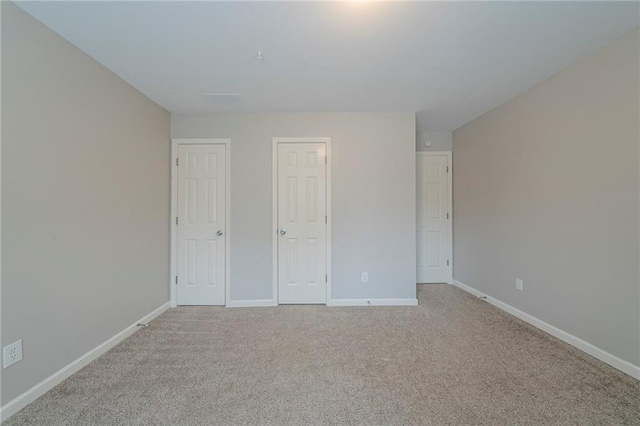 unfurnished bedroom featuring light colored carpet and baseboards