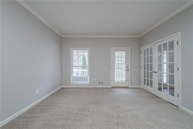 empty room with baseboards, french doors, visible vents, and crown molding