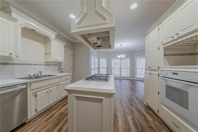 kitchen with a sink, white cabinets, stainless steel appliances, and light countertops