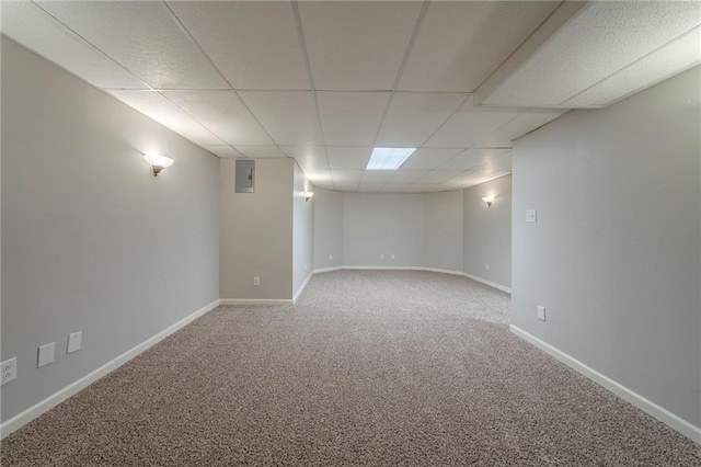 finished basement featuring carpet flooring, a drop ceiling, and baseboards