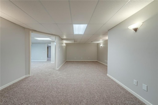 finished below grade area with carpet floors, a paneled ceiling, and baseboards