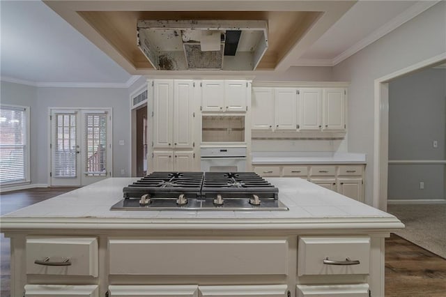 kitchen featuring stainless steel gas cooktop, light countertops, and white cabinetry