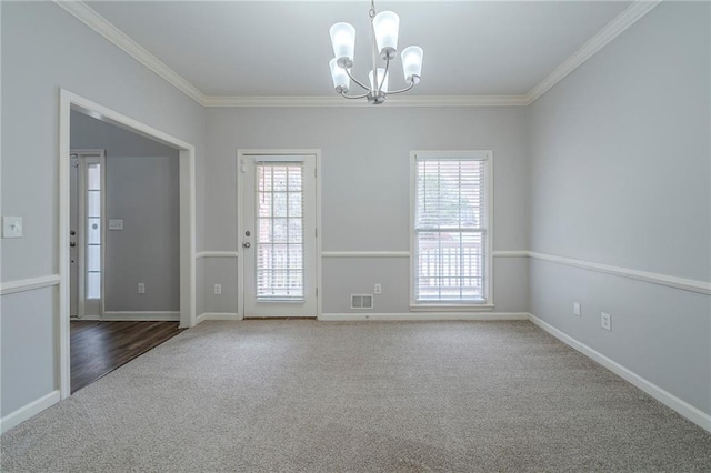 carpeted spare room featuring baseboards, ornamental molding, visible vents, and a notable chandelier