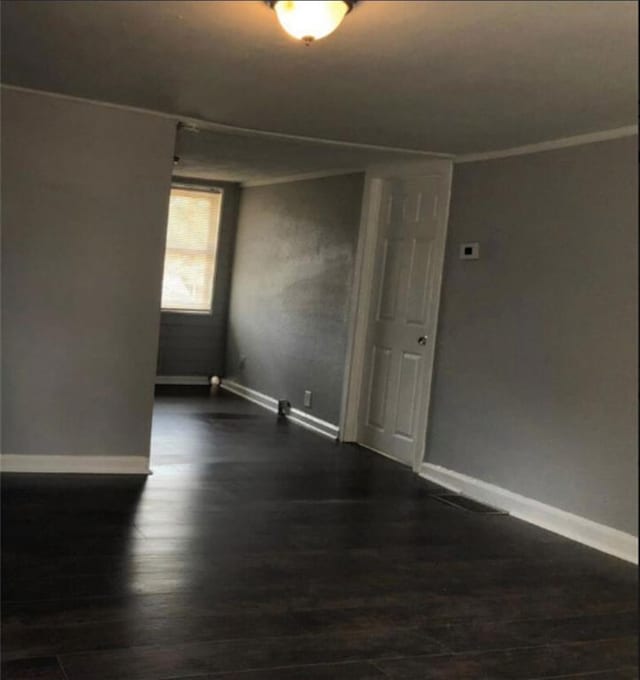 116 Lambert Dr, Stockbridge, GA 30281 - unfurnished room featuring crown molding, baseboards, and dark wood-style flooring