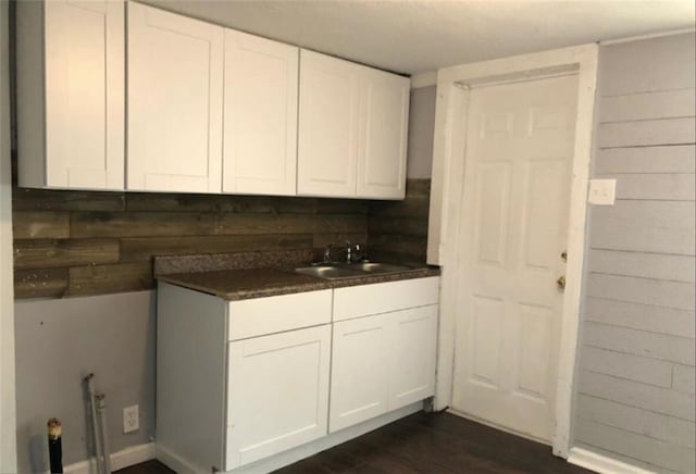 116 Lambert Dr, Stockbridge, GA 30281 - kitchen featuring white cabinetry, dark countertops, dark wood-style flooring, and a sink