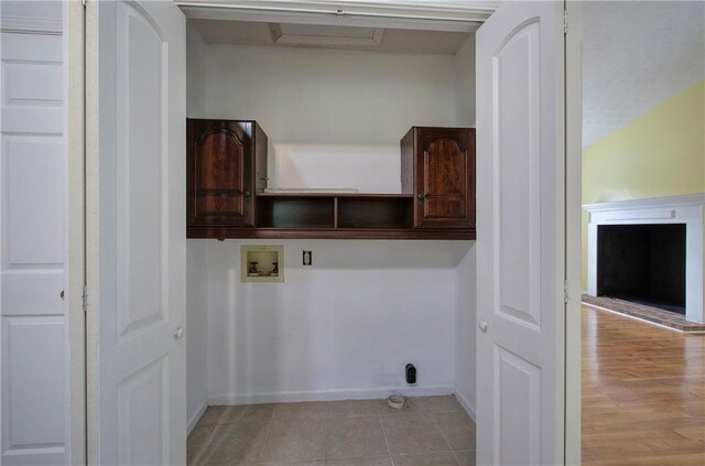 laundry room featuring cabinets, washer hookup, and light hardwood / wood-style flooring