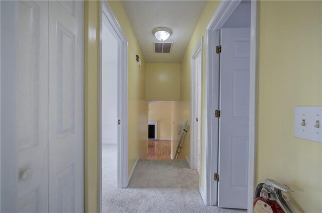 hallway featuring light colored carpet