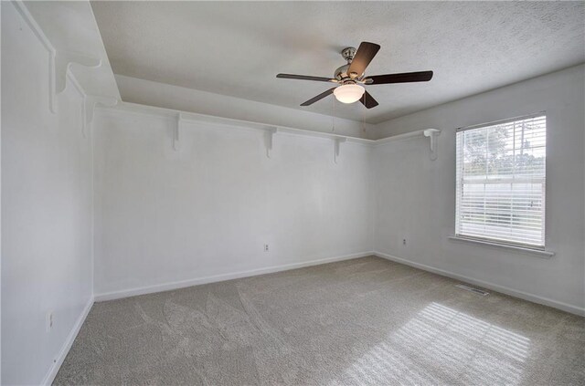 carpeted empty room featuring ceiling fan and a textured ceiling