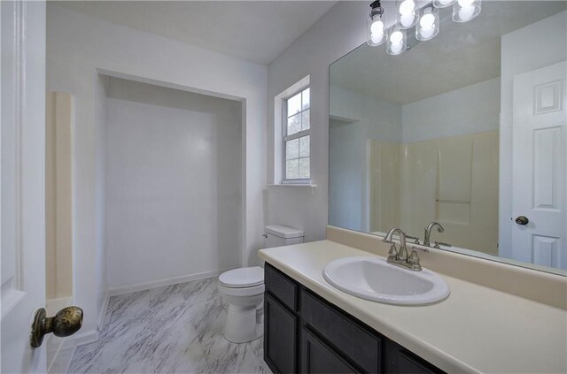 bathroom featuring walk in shower, vanity, and toilet