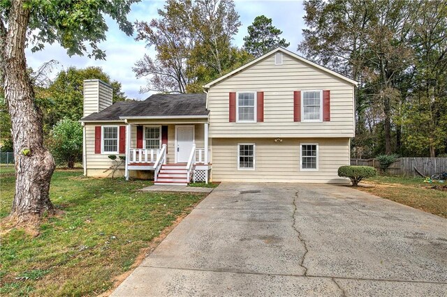 split level home featuring covered porch and a front lawn