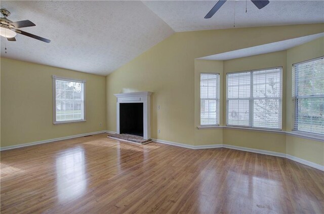 unfurnished living room featuring ceiling fan, a textured ceiling, light hardwood / wood-style flooring, and vaulted ceiling