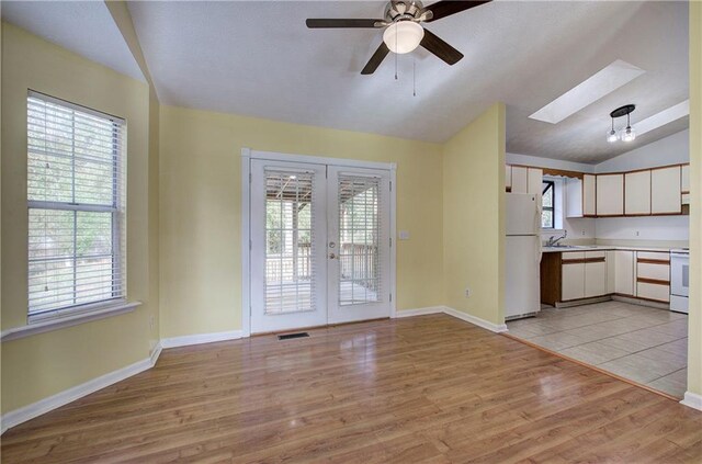 interior space featuring plenty of natural light, white appliances, and light hardwood / wood-style flooring