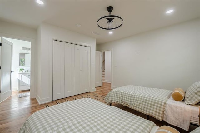 bedroom with baseboards, recessed lighting, a closet, and light wood-type flooring