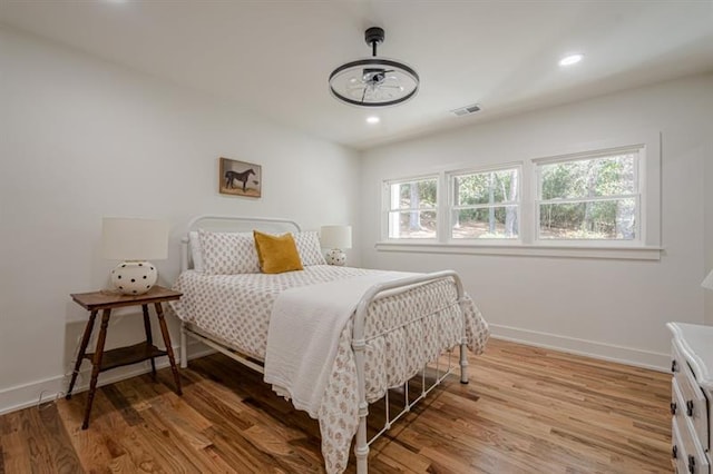 bedroom featuring visible vents, wood finished floors, and baseboards