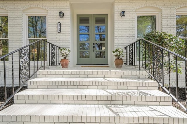 property entrance featuring brick siding and french doors
