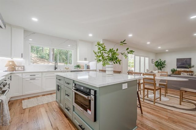 kitchen with light wood-style floors, plenty of natural light, and oven