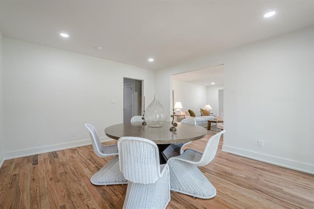 dining area featuring baseboards, light wood-style floors, and recessed lighting