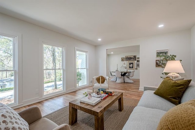 living room featuring baseboards, light wood-style flooring, and recessed lighting
