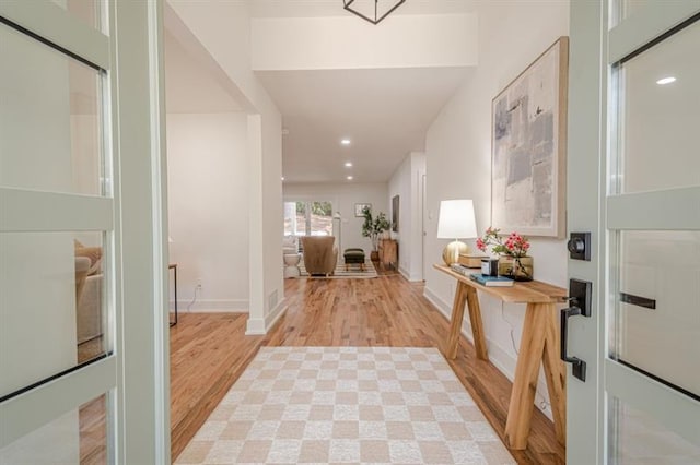foyer featuring light wood-type flooring, baseboards, and recessed lighting