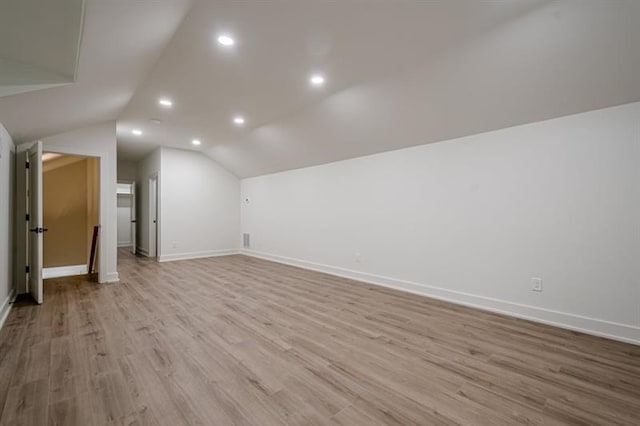 additional living space with vaulted ceiling, recessed lighting, baseboards, and wood finished floors