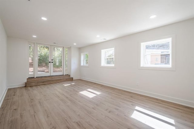 unfurnished living room with light wood finished floors, baseboards, french doors, and recessed lighting