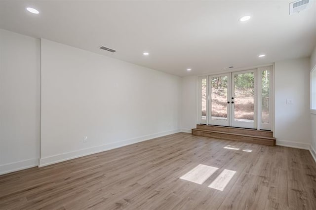 empty room featuring light wood-style flooring, french doors, and recessed lighting