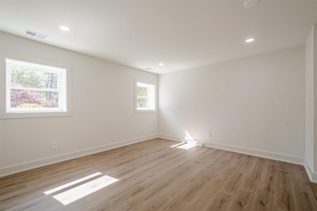 spare room featuring baseboards, light wood-type flooring, visible vents, and recessed lighting