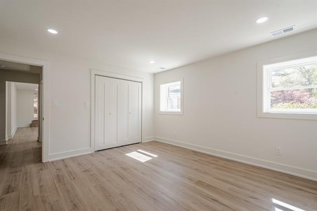 unfurnished bedroom with a closet, visible vents, recessed lighting, baseboards, and light wood-style floors