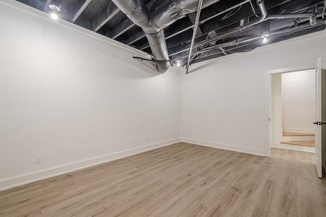 finished below grade area with light wood finished floors and baseboards