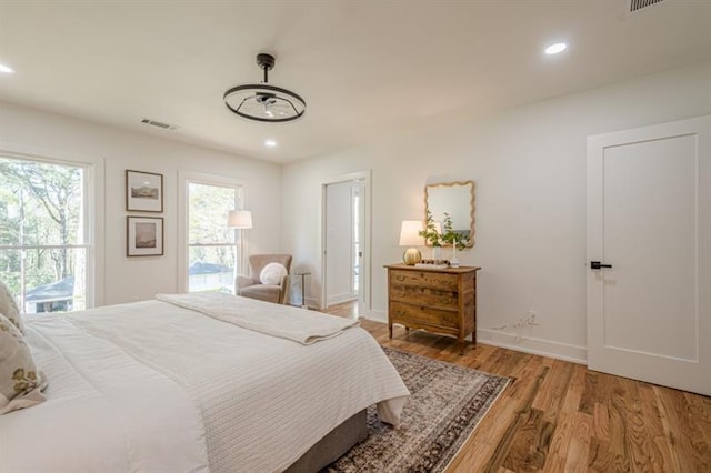 bedroom with light wood-style floors, visible vents, baseboards, and recessed lighting