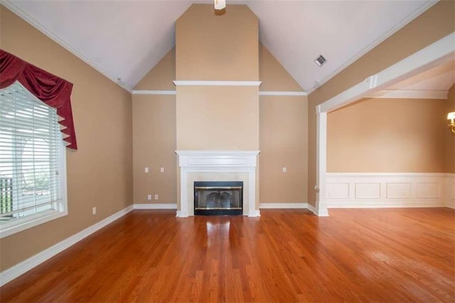 unfurnished living room featuring hardwood / wood-style flooring, ornamental molding, and high vaulted ceiling