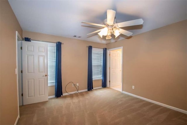 unfurnished room with ceiling fan, plenty of natural light, and light colored carpet