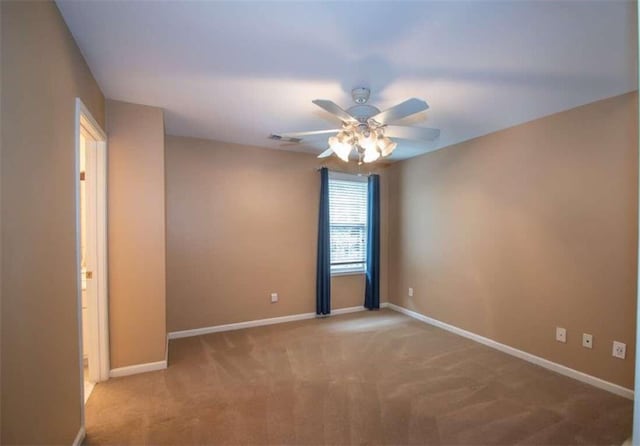 empty room with ceiling fan and light colored carpet